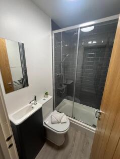 Contemporary ensuite bathroom with a glass-encl...