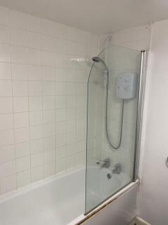 A functional bathroom with a shower featuring a...