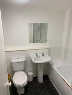 A clean, functional bathroom featuring a toilet...