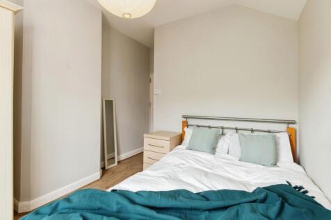 A well-maintained bedroom featuring a large bed...