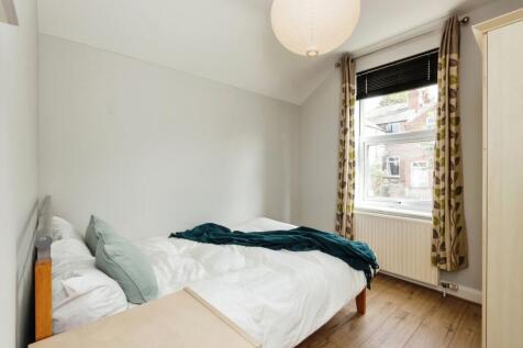 A bright and tidy bedroom featuring a comfortab...