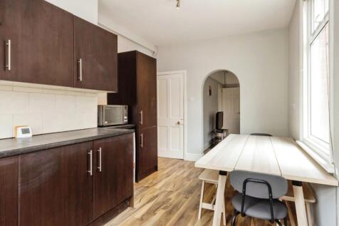 A modern kitchen area featuring dark wood cabin...