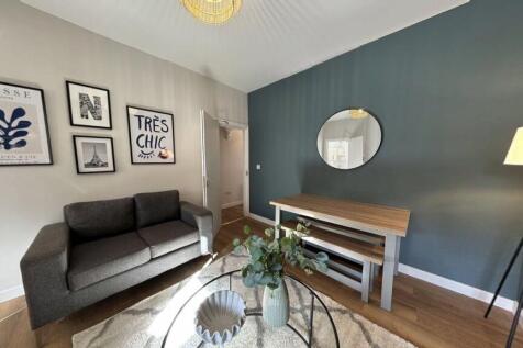 A bright, stylish living room featuring a comfo...