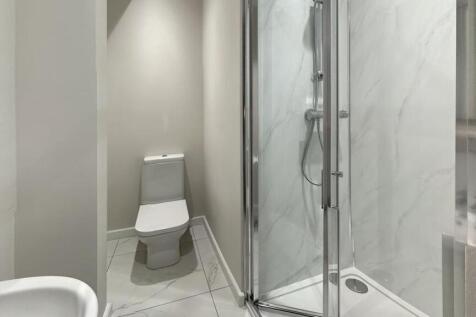 A modern, clean bathroom with a spacious shower...