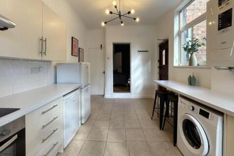 Modern and bright kitchen space featuring white...