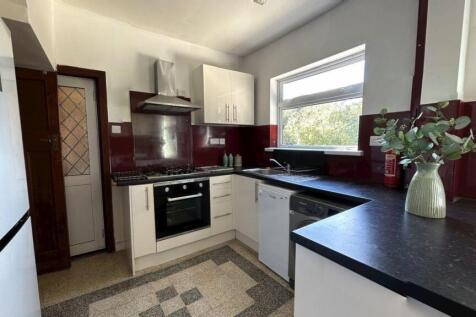 A modern kitchen featuring white cabinets, a bl...
