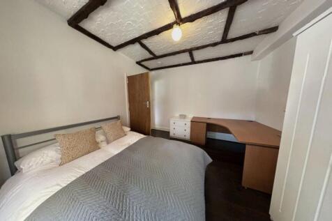 A cozy double bedroom featuring a large bed wit...