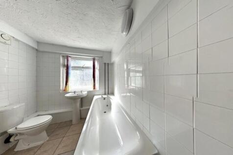 Bright and clean bathroom featuring a bathtub, ...