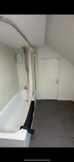 A compact bathroom featuring a bathtub with a s...