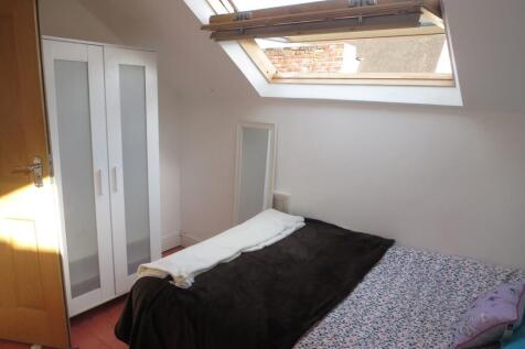 A cozy single bedroom with a skylight window pr...