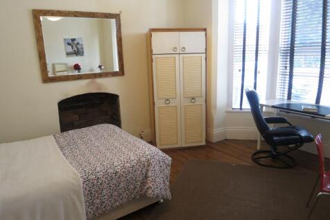 A cozy single bedroom with a comfortable bed, a...