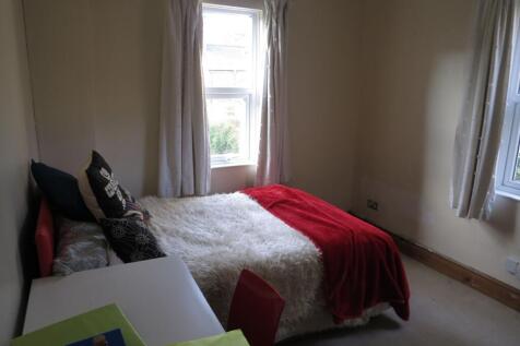 A cozy bedroom featuring a double bed adorned w...