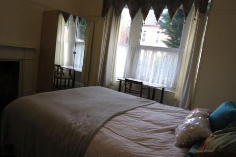 A cozy bedroom with a large window allowing nat...