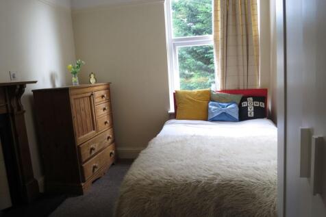 A cozy single bedroom featuring a comfortable b...