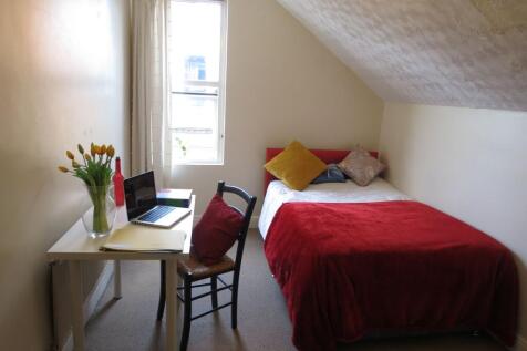 Bright and cozy single bedroom featuring a comf...