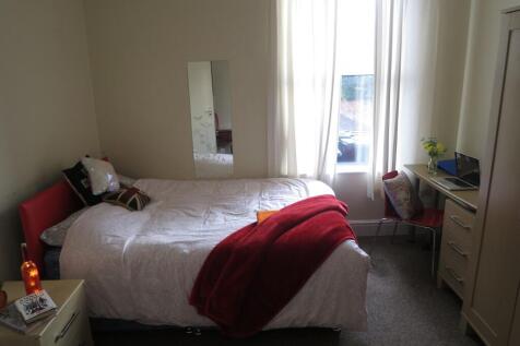 Bright and inviting bedroom featuring a cozy be...