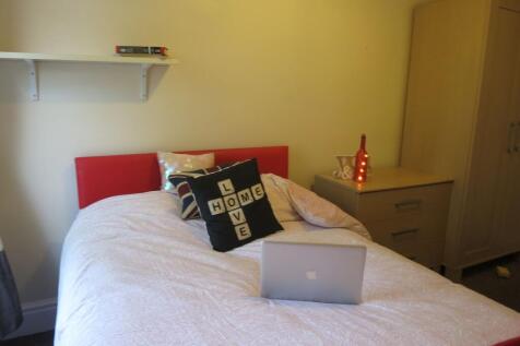 Cozy double bedroom featuring a neatly made bed...