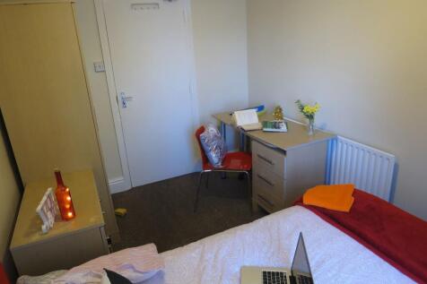 A well-kept bedroom featuring a single bed with...