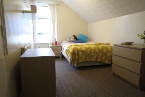 A cozy double bedroom with a comfortable bed dr...