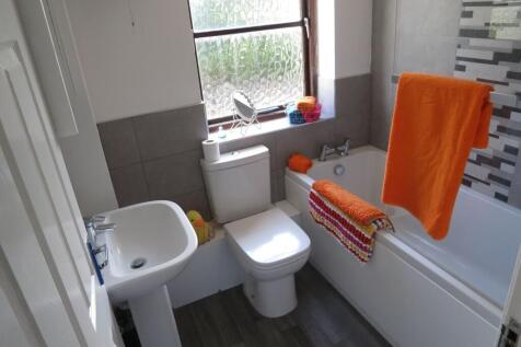 Bright and clean bathroom featuring a bathtub w...