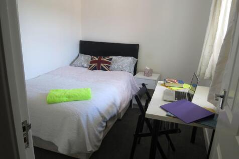 A well-lit double bedroom featuring a comfortab...