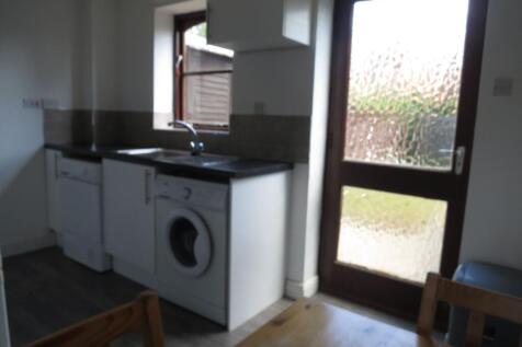A compact kitchen area featuring a washing mach...