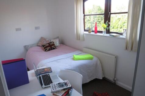 A cozy, well-lit bedroom featuring a comfortabl...