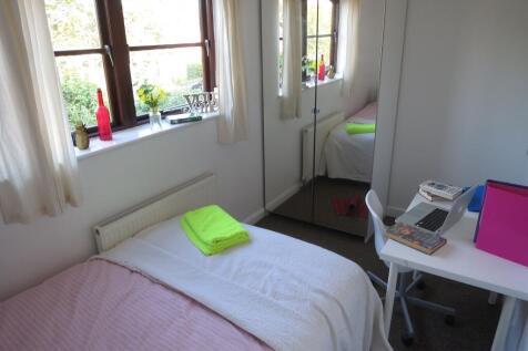 Bright and tidy student bedroom featuring a com...