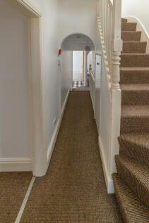 Bright, neutrally decorated hallway with carpet...