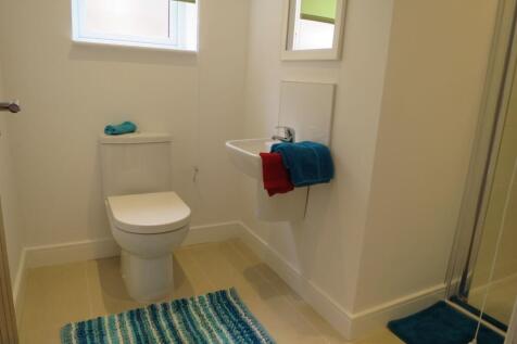 Bright and tidy bathroom featuring a toilet, sm...