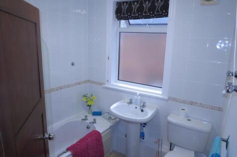 Bright and clean bathroom featuring a bathtub, ...