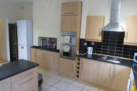 Modern kitchen with wooden cabinets, black coun...