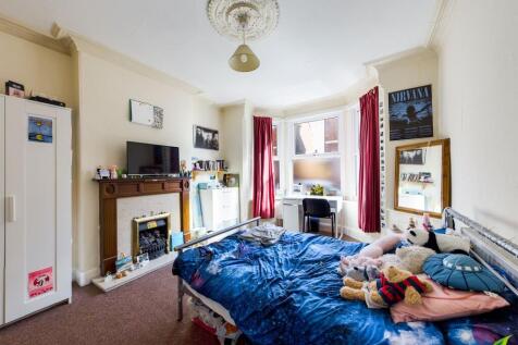 A cozy bedroom featuring a bed with stuffed toy...