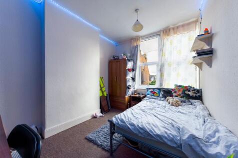 A cozy single bedroom featuring a bed with play...