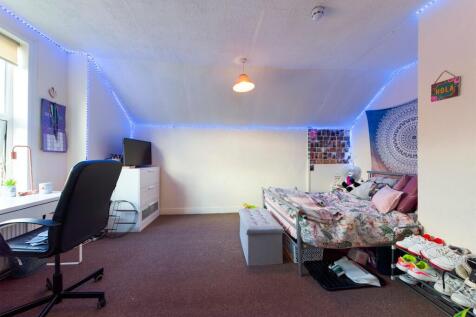 A bright and cozy bedroom with a comfy bed, a s...