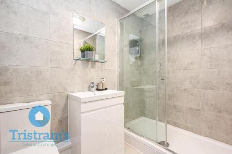 Modern tiled bathroom with a glass-enclosed sho...