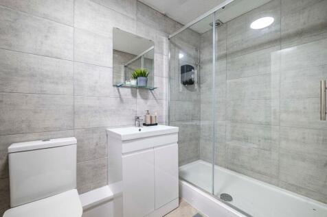 Modern tiled bathroom with a glass-front shower...