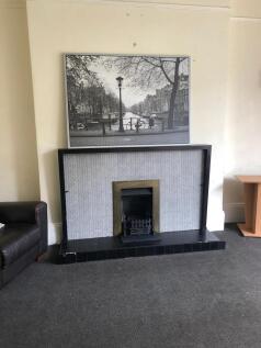 A cozy living room featuring a fireplace and a ...