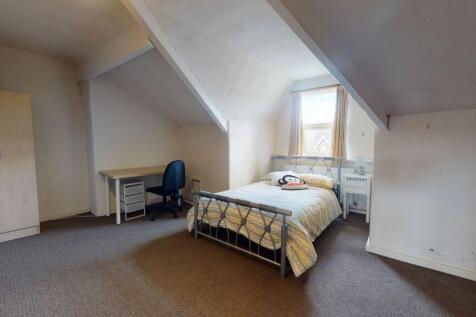 A cozy bedroom with a single bed, a desk and ch...