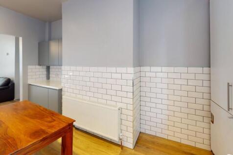 Modern kitchen area featuring white subway tile...