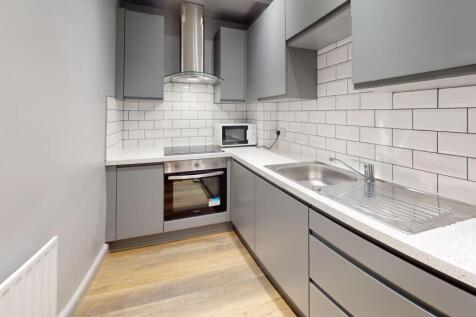 A modern, clean kitchen with sleek gray cabinet...