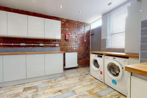 Modern kitchen with sleek white cabinets, timbe...