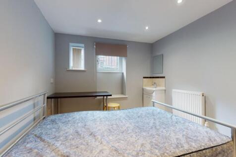 A clean and bright bedroom featuring a bed, a s...