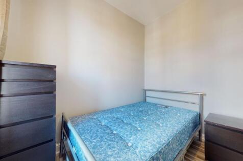 The room features a single bed with a metal fra...