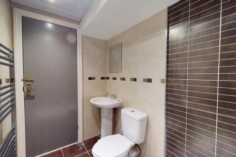 A modern, compact bathroom featuring a white to...