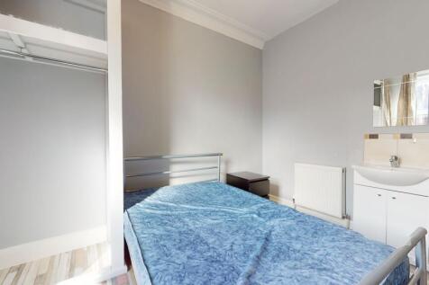 A cozy single bedroom featuring a bed with blue...