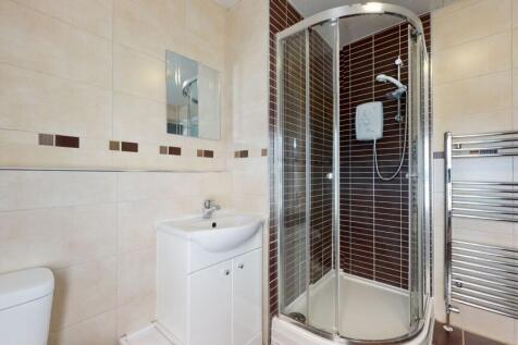 A clean and modern bathroom featuring a corner ...