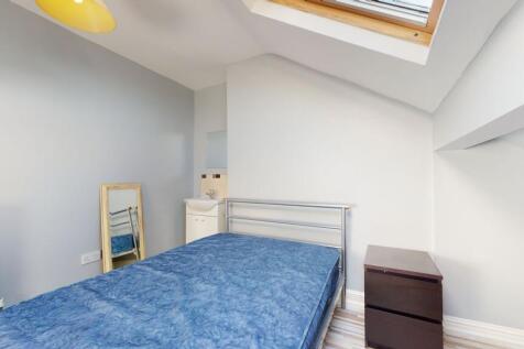 A compact bedroom featuring a metal-framed sing...