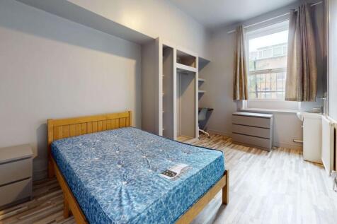 A bright, tidy bedroom featuring a double bed, ...