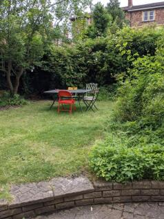 A well-maintained garden with a table and chair...